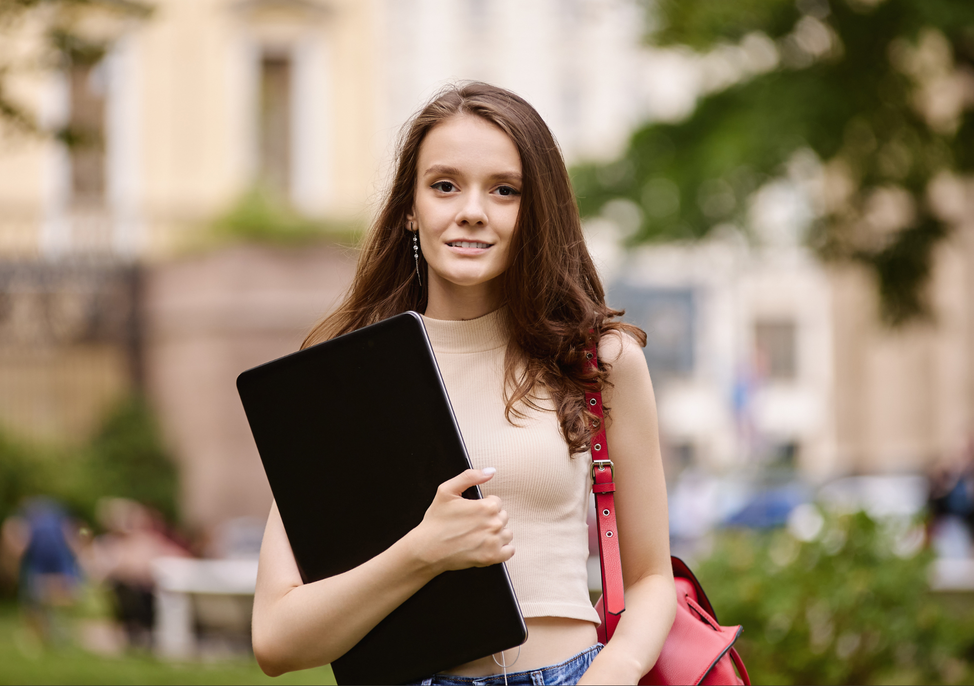 Estudante com laptop e mochila em ambiente externo, ilustrando quando filho maior de idade tem direito à pensão alimentícia por estar em curso superior.